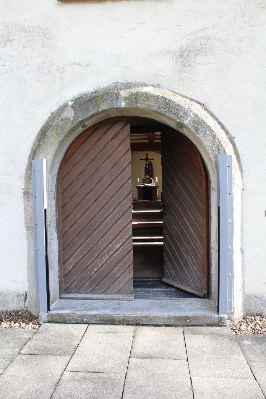 Das Bild zeigt ein Tor in eine Kapelle, als Sinnbild für immer offene Türen. 